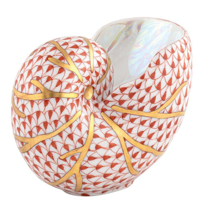 The Herend Nautilus Shell is a collectible porcelain vase featuring a red fish scale pattern and gold veining on white, showcasing timeless elegance.