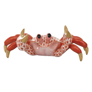 The Herend Sand Crab is a collectible porcelain figurine featuring a red and white patterned body, gold-tipped claws, and black eyes, positioned on its back with legs raised—a timeless decorative accent for any space.