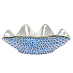 The Herend Clam Shell Collection features a white porcelain bowl with a wavy rim, gold trim, and hand-painted blue fish scale pattern, inspired by classic Herend porcelain design.