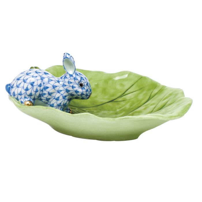 The Herend Bunny on Cabbage Leaf features a blue and white patterned rabbit figurine atop a green ceramic leaf dish, making it a timeless decorative accent.