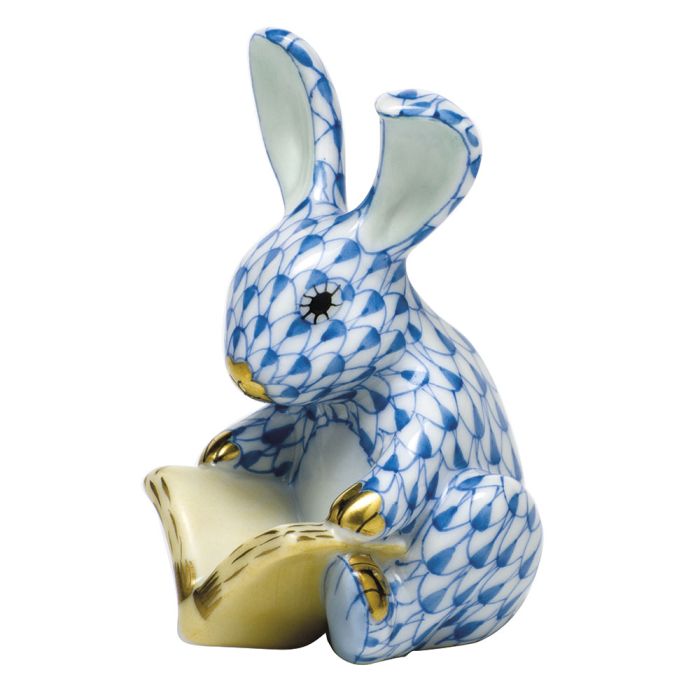 The Herend Storybook Bunny is a blue and white porcelain collectible figurine with gold accents, featuring an upright rabbit holding an open book—an elegant decorative piece for any space.