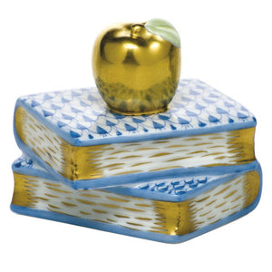 The Herend "Apple on Books" features two stacked porcelain books with blue patterns, crowned by a gold apple with a green leaf—a charming accent that adds timeless elegance to any space.