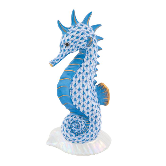The Herend "Seahorse on Scallop Shell" is a hand-painted ceramic figurine featuring a blue fish scale pattern, gold accents, and an iridescent base—an elegant decorative accent.
