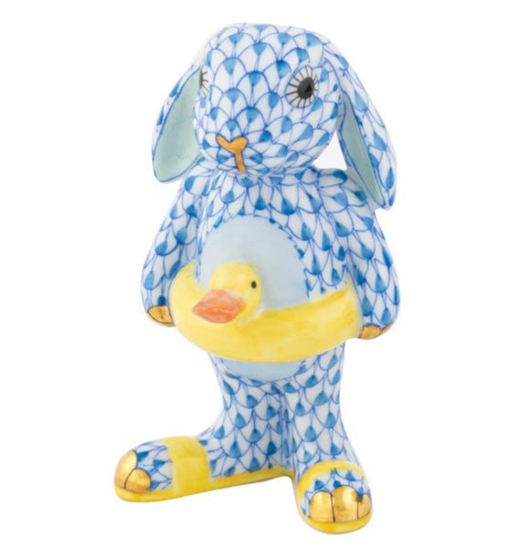 The Herend Beach Bunny, Blue is a beautifully hand-painted porcelain figure of a bunny holding a yellow duck float, epitomizing elegance and craftsmanship, perfect for collectors.