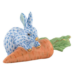 Carrot Love by Herend—a blue and white patterned porcelain rabbit resting on an orange carrot with green leaves. This collectible piece brings timeless elegance to any decorative display.