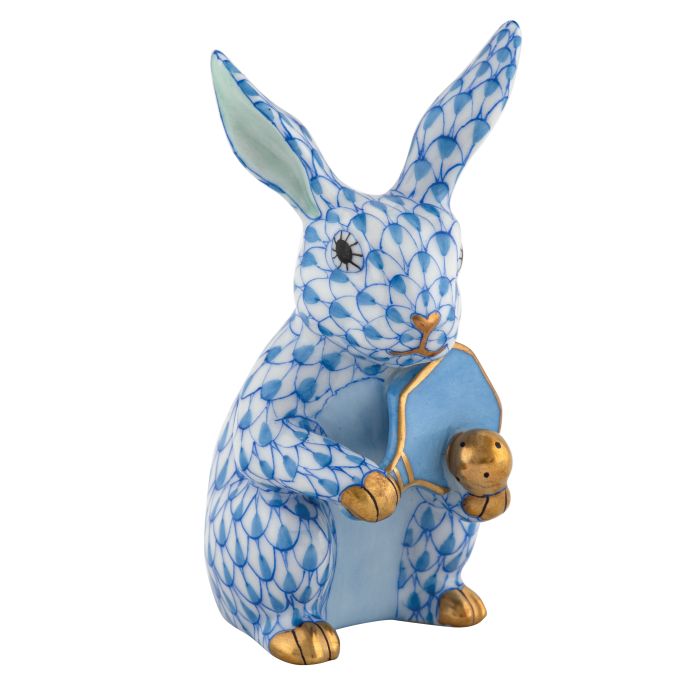 Herend Pickleball Bunny: a collectible porcelain rabbit figurine in blue and white scale pattern with gold accents, holding a small gold chick and a blue pickleball—a timeless piece.
