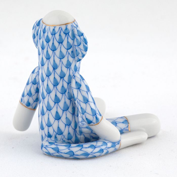 Herend Sock Monkey porcelain figurine, hand painted in blue fish scale with gold accents, shown seated from the back against a plain white background.