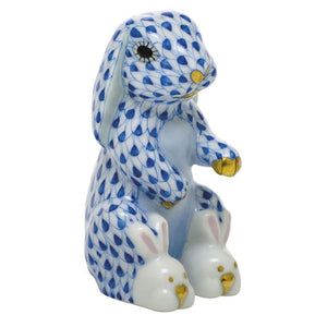 The Herend Bunny Slippers is a hand-painted porcelain rabbit figurine featuring a blue fishnet pattern, gold accents, and cute bunny-shaped slippers—a delightful decorative accent for any space.