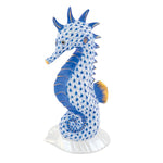 The Herend "Seahorse on Scallop Shell" is a hand-painted porcelain figurine in blue and white fishnet with gold accents, standing on a white base—a charming decorative accent for any space.