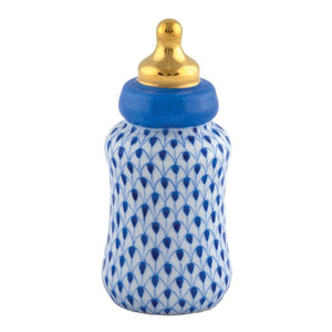 The Herend Baby Bottle features hand-painted porcelain with a blue scaled pattern, a blue collar, and a gold-colored nipple, serving as an elegant decorative accent on any white background.
