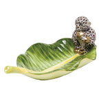 The Herend Monkey on Banana Leaf is a collectible porcelain dish, shaped like a green leaf with a decorative monkey on one end—an elegant piece for any setting.