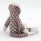 A Herend porcelain Sock Monkey figurine, hand painted with a brown and white scale-like pattern, is displayed on a white surface with its back facing the camera.