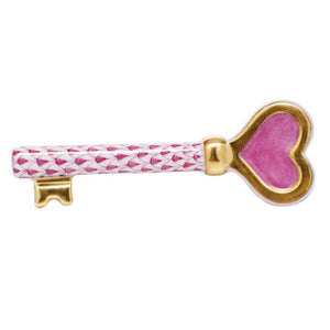The Key To My Heart, Raspberry by Herend features a pink and white patterned shaft with a heart-shaped gold and pink bow, showcasing beautiful hand-painted designs that highlight its artistic charm.