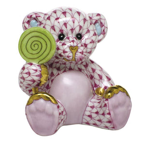 Herend’s Sweet Tooth Teddy: a pink and white patterned porcelain bear with gold-accented paws and ears, holding a green lollipop—an elegant collectible to enhance any décor.