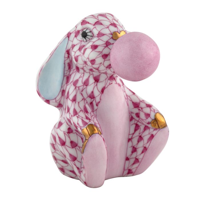 Herend’s Bubble Gum Bunny is a collectible porcelain figurine featuring a pink pattern, gold accents, blue inner ears, and a pink bubblegum bubble—an enchanting decorative piece with timeless charm.