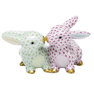 The Herend Kissing Bunnies, Raspberry & Key Lime, are two hand-painted porcelain rabbit figurines with gold accents, posed nose-to-nose—an enchanting decorative accent for any collection.