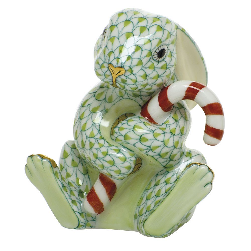 The Herend Candy Cane Bunny is a porcelain figurine featuring a green patterned rabbit holding a red and white striped candy cane—ideal for festive collections or bringing holiday charm to your décor.