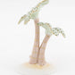 The Herend Palm Tree is a porcelain figurine featuring two stylized palm trees with patterned green leaves, gold accents, and hand-painted details on a circular white base.