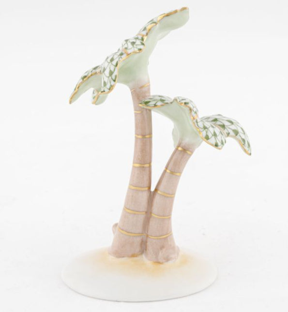 The Herend Palm Tree is a porcelain figurine featuring two stylized palm trees with patterned green leaves, gold accents, and hand-painted details on a circular white base.