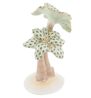 The Herend Palm Tree is a hand-painted porcelain figurine featuring patterned green leaves, gold accents, and a light brown trunk on a white base.