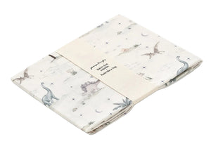 The Gooselings Dino Dreams Swaddle, made from 100% cotton with a subtle dinosaur print, comes folded and wrapped in a minimalist packaging band.