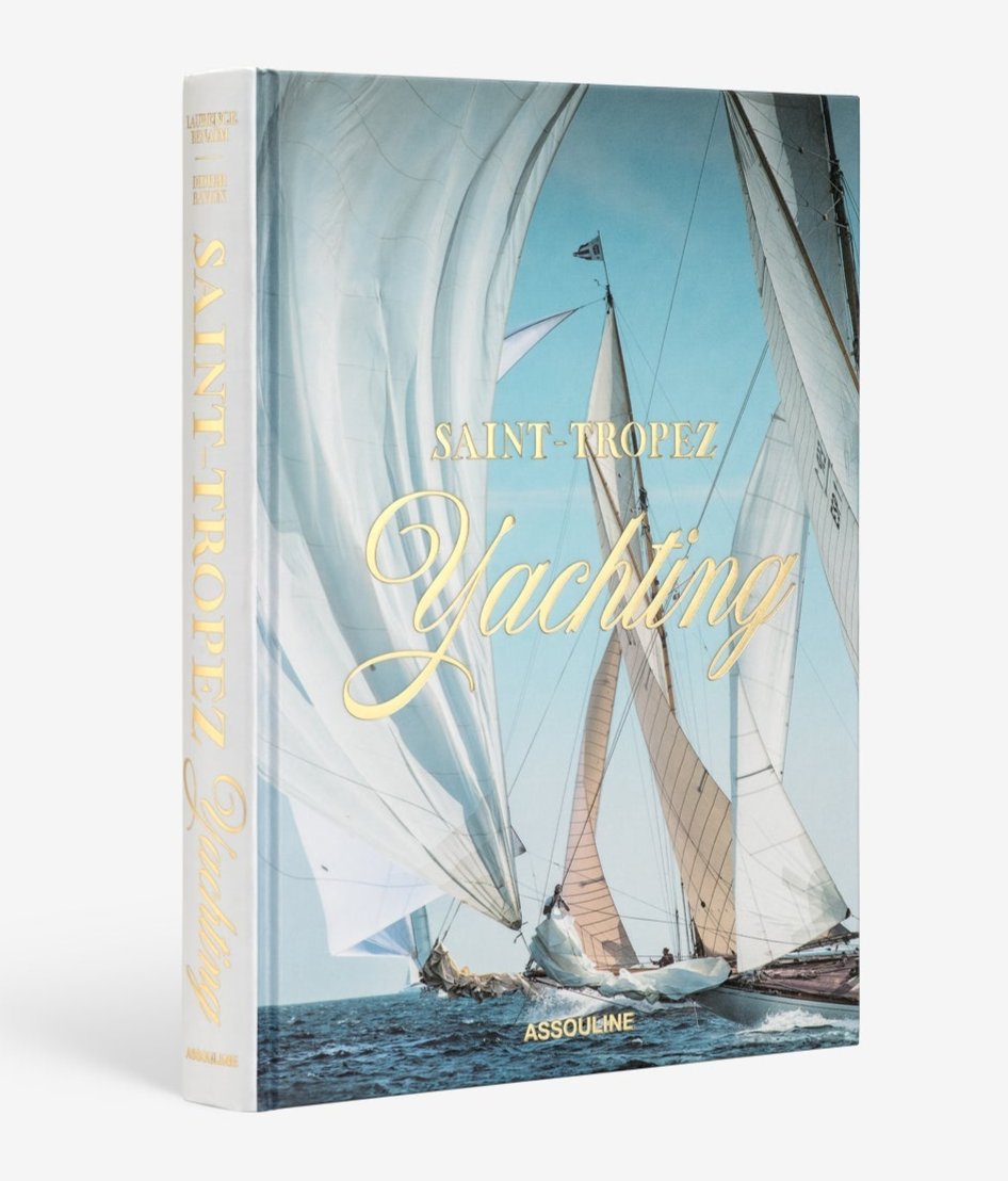 The Assouline book "Saint Tropez Yachting" showcases the vibrant Mediterranean sailing essence, with a cover image of sailboats gliding under a blue sky, reminiscent of the iconic Voiles de Saint-Tropez.