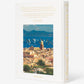 The book "Saint Tropez Yachting" by Assouline showcases a sunlit Mediterranean sailing scene with a charming seaside town and numerous sailboats, evoking the famous Voiles de Saint-Tropez.