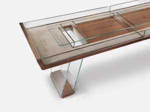 The Scivolo Shuffleboard Game Table by Impatia features a glass top, wooden accents, and metal supports, with a rectangular glass compartment and minimalist design inspired by Italian craftsmanship.