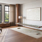 Modern living room with large windows, light rug, Scivolo Shuffleboard Game Table by Impatia with a glass top, wooden sideboard showcasing Italian craftsmanship, armchair, floor lamp, and abstract painting on a white wall.