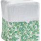 A white Italian linen tissue box cover from Haute Home’s Boxwood Bath Collection, featuring green leaf and flower embroidery along the bottom edge.