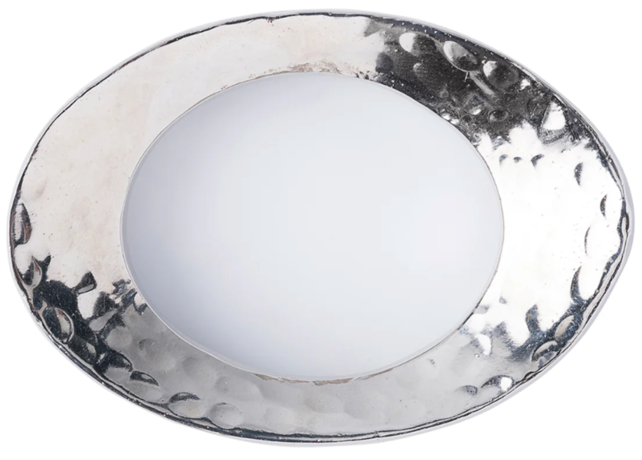 The Juliska Puro Napkin Ring is an oval silver-colored aluminum piece with nickel plating, a hammered texture, and a smooth, slightly raised rim.