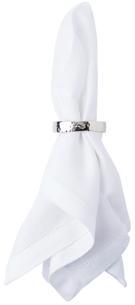 A white cloth napkin is folded and held upright by a Juliska Puro Napkin Ring, crafted from aluminum with nickel plating.