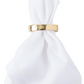 A white cloth napkin is elegantly folded and secured by the Juliska Puro Napkin Ring.
