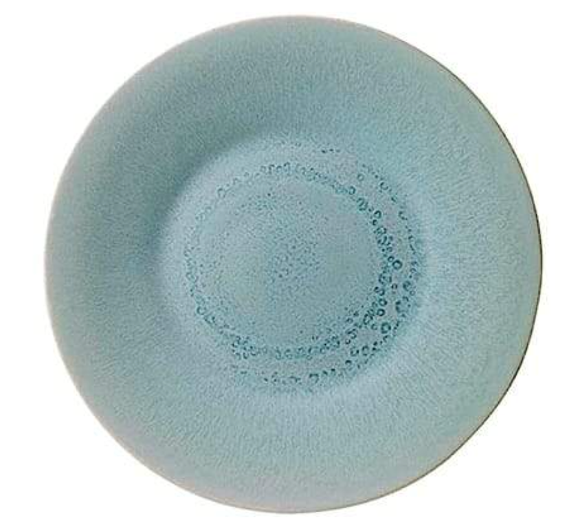 The Jars Vuelta Ocean Blue Collection plate features a round, light blue ceramic design with a raised rim and speckled texture—timelessly elegant for serving fruit cups or desserts.