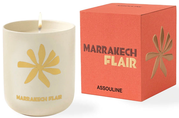 A scented candle labeled "Travel Candle Marrakech Flair" by Assouline beside its packaging box.