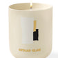 The Assouline Travel Candle Gstaad Glam, in a cream container with abstract white, gold, and black shapes and "Gstaad Glam" text, offers a winter escape vibe. Ideal for a Travel from Home Candle experience.