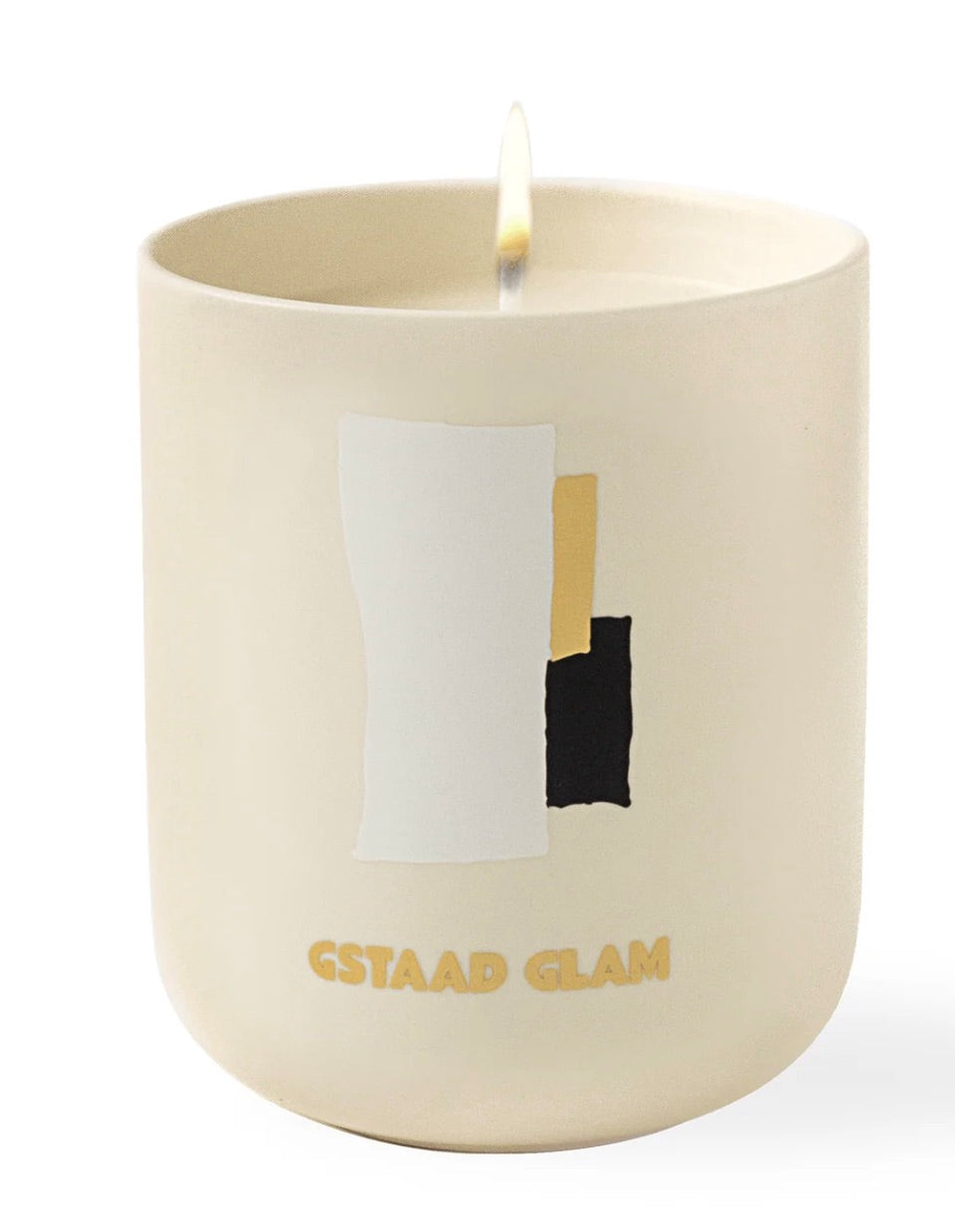The Assouline Travel Candle Gstaad Glam, in a cream container with abstract white, gold, and black shapes and "Gstaad Glam" text, offers a winter escape vibe. Ideal for a Travel from Home Candle experience.