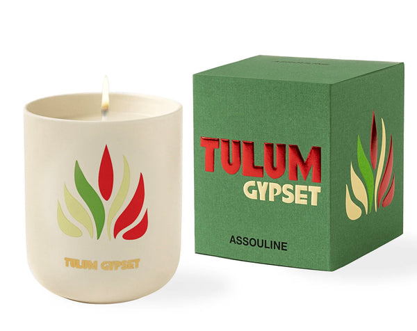 A scented candle with the label "Travel Candle Tulum Gypset" next to its green packaging box with matching design from Assouline.