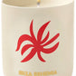 An Assouline Travel Candle Ibiza Bohemia sits in a beige container decorated with a red abstract design, releasing subtle patchouli undertones.