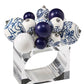 The Kim Seybert Cloud Napkin Ring, featuring a clear Lucite band adorned with blue, white, and patterned ceramic and acrylic baubles, brings an artful accent to your table setting.