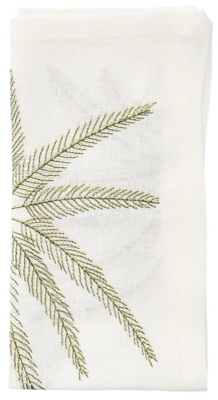 Elevate your coastal dining table with the Kim Seybert Palm Coast Napkin Set—white napkins featuring green embroidered palm fronds, neatly folded for a refined touch.