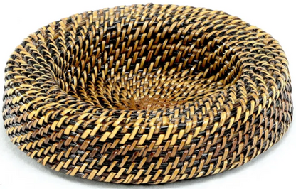 The Calaisio Rattan Wine Collection features a handcrafted, round, flat-bottomed woven basket with high curved sides and alternating brown, black, and tan bands—showcasing unique artisanal craftsmanship.