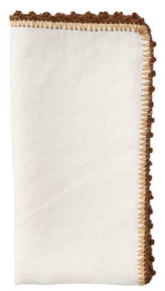 A Kim Seybert Knotted Edge Napkin, Set of 4 with a decorative brown fringe trim on the edges, machine washable and isolated on a white background.