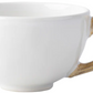 A white ceramic cup from Juliska’s Classic Bamboo Dinnerware Collection has a bamboo-shaped handle, adding casual elegance and global style to your table.