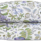 Two pillows from the Matouk Pomegranate Roman Linen Bedding Collection in Lilac are stacked on a white background, showcasing a green, purple, and blue floral pattern in OEKO-TEX Standard 100 certified soft Roman linen.