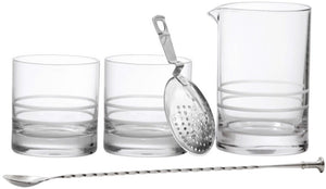 The Fortessa Crafthouse 5-Piece Mixing Set—three clear glass tumblers, a mixing pitcher, metal strainer, and twisted bar spoon—is arranged in a row on a white background.