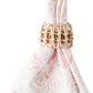 Juliska’s Provence Napkin Ring, hand-woven from rattan, elegantly secures a white napkin featuring a subtle pink and beige floral pattern—perfect for enhancing your table setting.