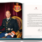 An open book displaying a formal portrait of a bald man in military dress uniform with decorations, seated next to a page of text with a signature at the bottom, possibly from the archives of the Prince’s Palace of Monaco by Assouline.