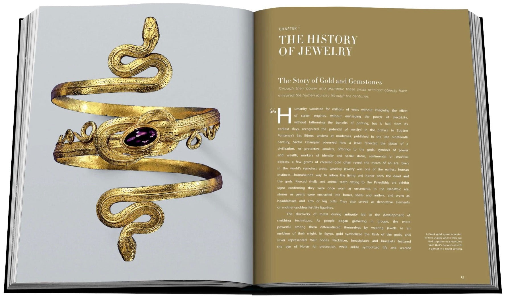 Open book with gold cover, featuring Chapter 1 titled "The History of Jewelry." The left page shows a gold snake bracelet adorned with a purple gem, and the right page contains text detailing the chapter's rich exploration of jewels and precious metals. **Jewelry Guide: The Ultimate Compendium by Assouline** offers an exquisite look into the history and artistry of jewelry.