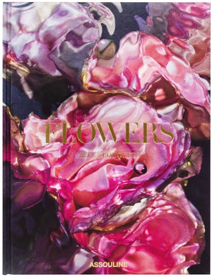 A book cover titled "Flowers: Art & Bouquets" by Assouline featuring a close-up of distorted, translucent floral shapes with pink and purple hues, showcasing the expertise of floral artists.